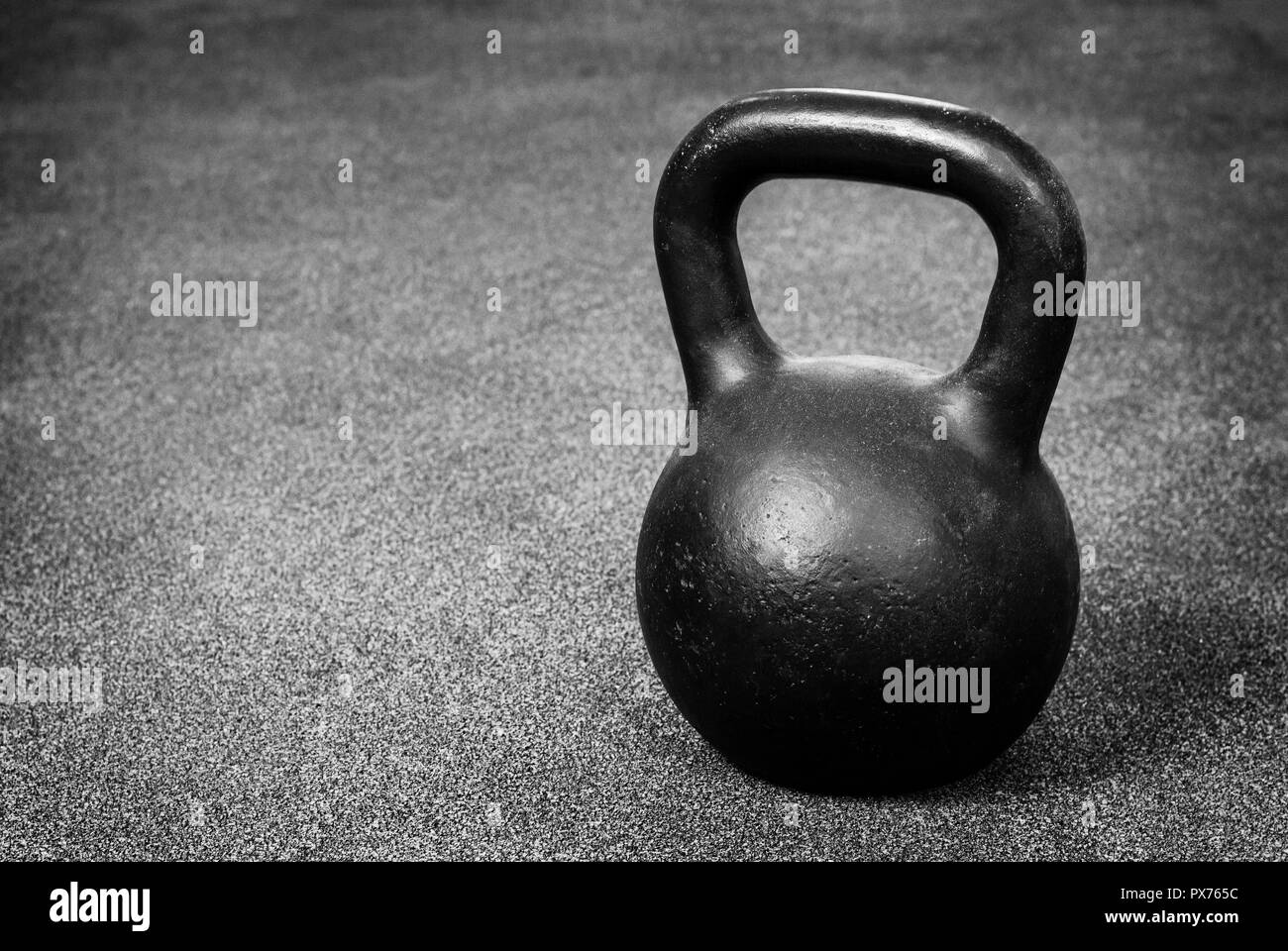 Nero kettlebell pesanti sul pavimento grigio, sollevamento pesi Foto Stock