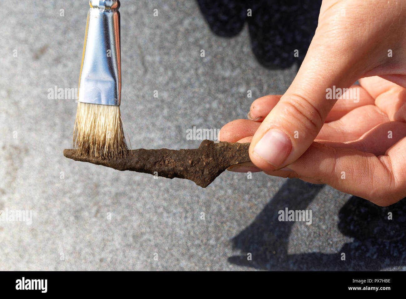 Archeologo pulisce il suolo arrugginito ferro medievale punta di freccia Foto Stock