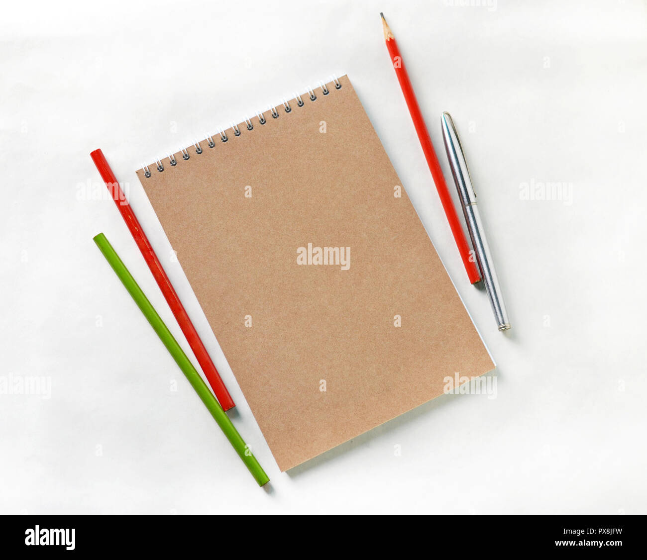 Appunti con matite e penne di colore bianco su sfondo isolato. Foto Stock