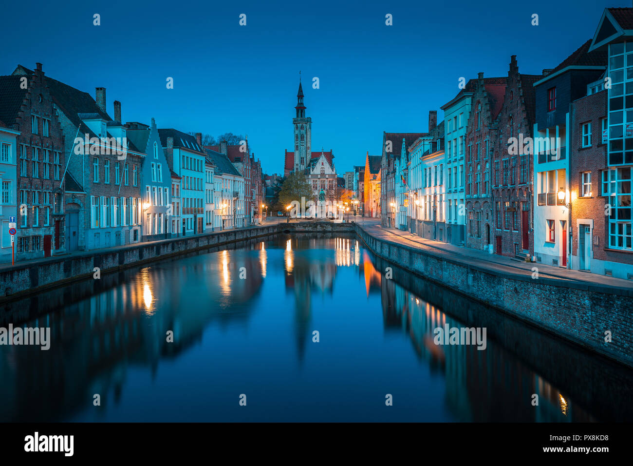 Bella vista panoramica del famoso Spiegelrei canal con il famoso Poortersloge e Jan van Eyck square in sottofondo accesa durante ore blu Foto Stock