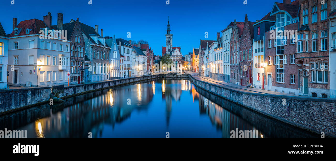Bella vista panoramica del famoso Spiegelrei canal con il famoso Poortersloge e Jan van Eyck square in sottofondo accesa durante ore blu Foto Stock