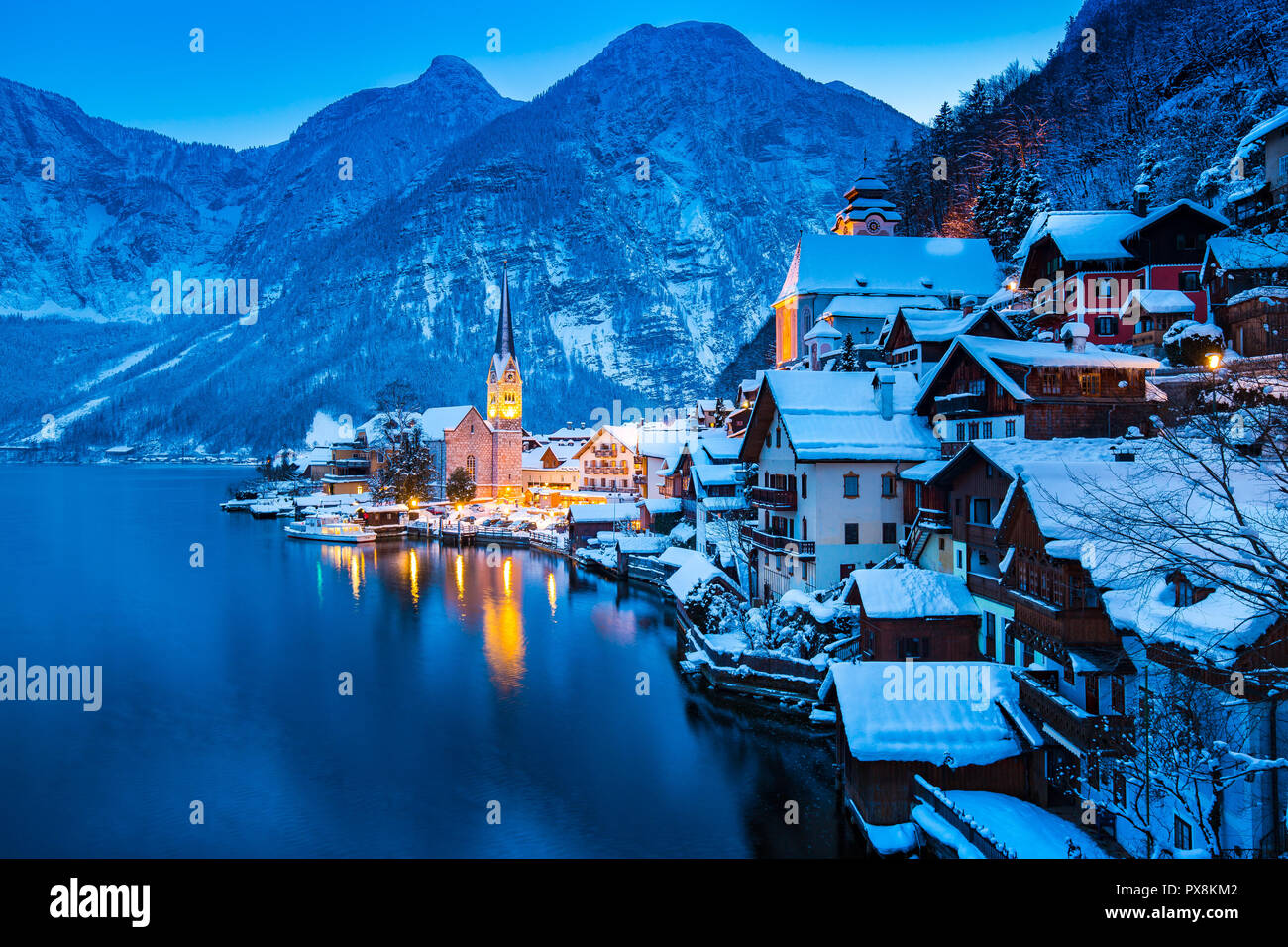 Classic vista da cartolina famosa Hallstatt Lakeside Town nelle Alpi con belle Hallstattersee nel post mistico tramonto crepuscolo durante il blu ora a Foto Stock