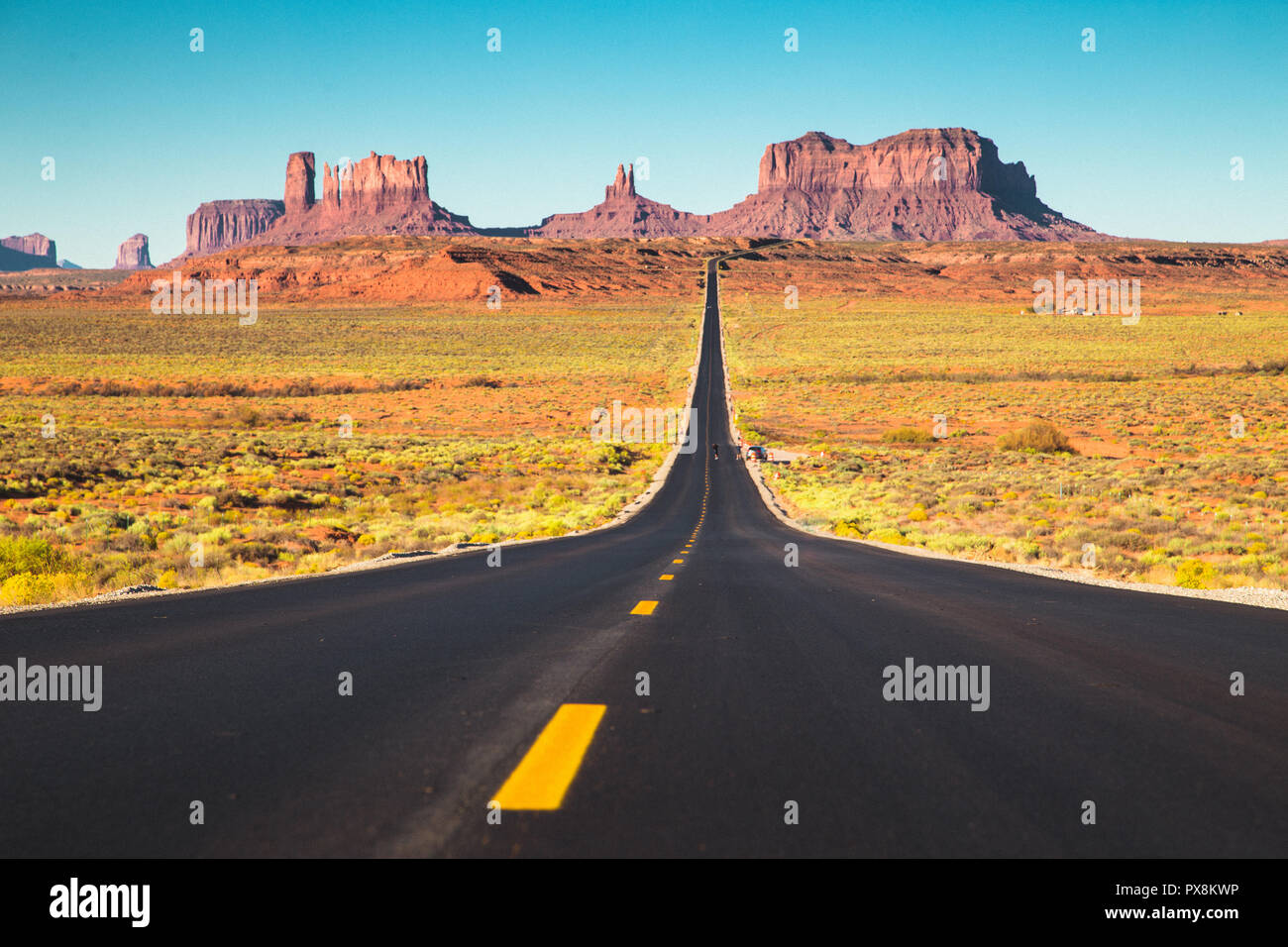Classic vista panorama del centro storico di U.S. Percorso 163 in esecuzione attraverso la famosa Monument Valley in beautiful Golden luce della sera al tramonto in estate, Utah, U Foto Stock