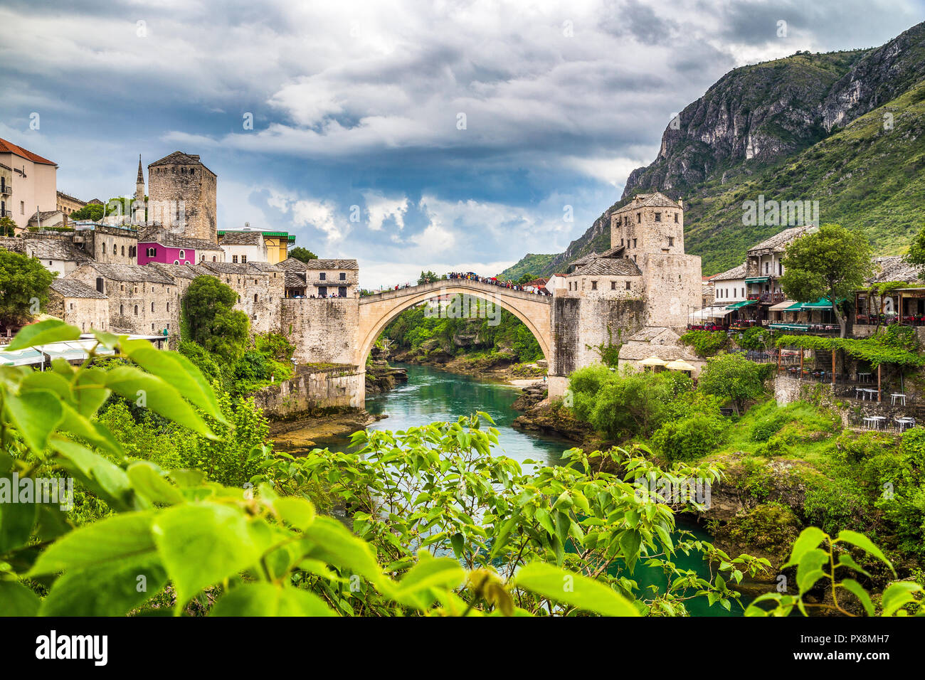 Vista panoramica del centro storico di Mostar con il famoso Ponte Vecchio (Stari Most), un sito Patrimonio Mondiale dell'UNESCO dal 2005, in un giorno di pioggia con scuri c Foto Stock