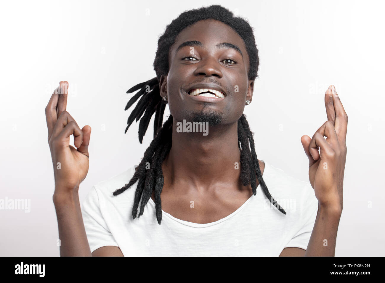 African American maschio incrocia le dita, scuro scuoiati uomo desidera sogni Foto Stock