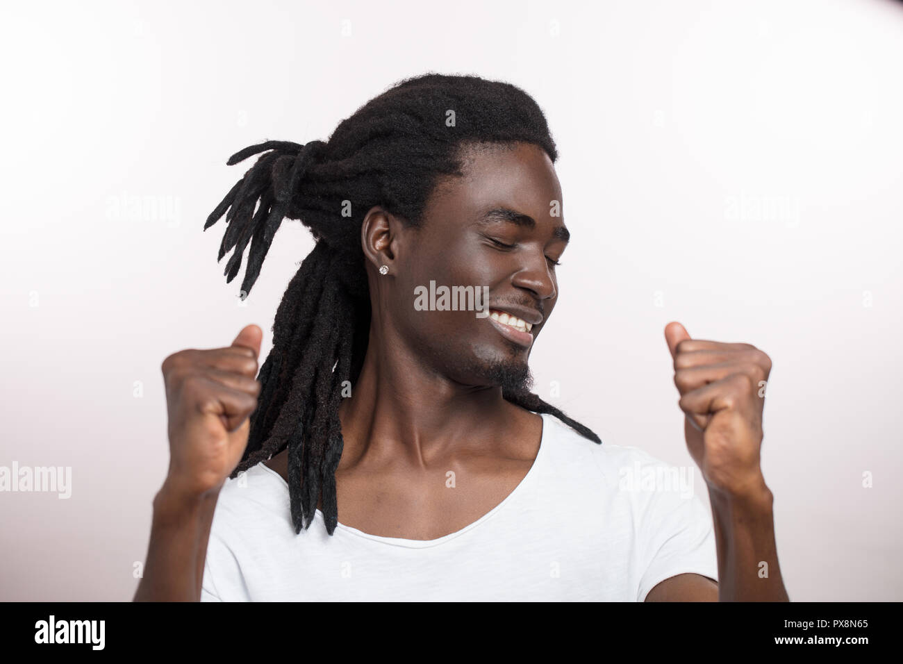 Bello felice del giovane africano con dreadlocks su sfondo bianco Foto Stock