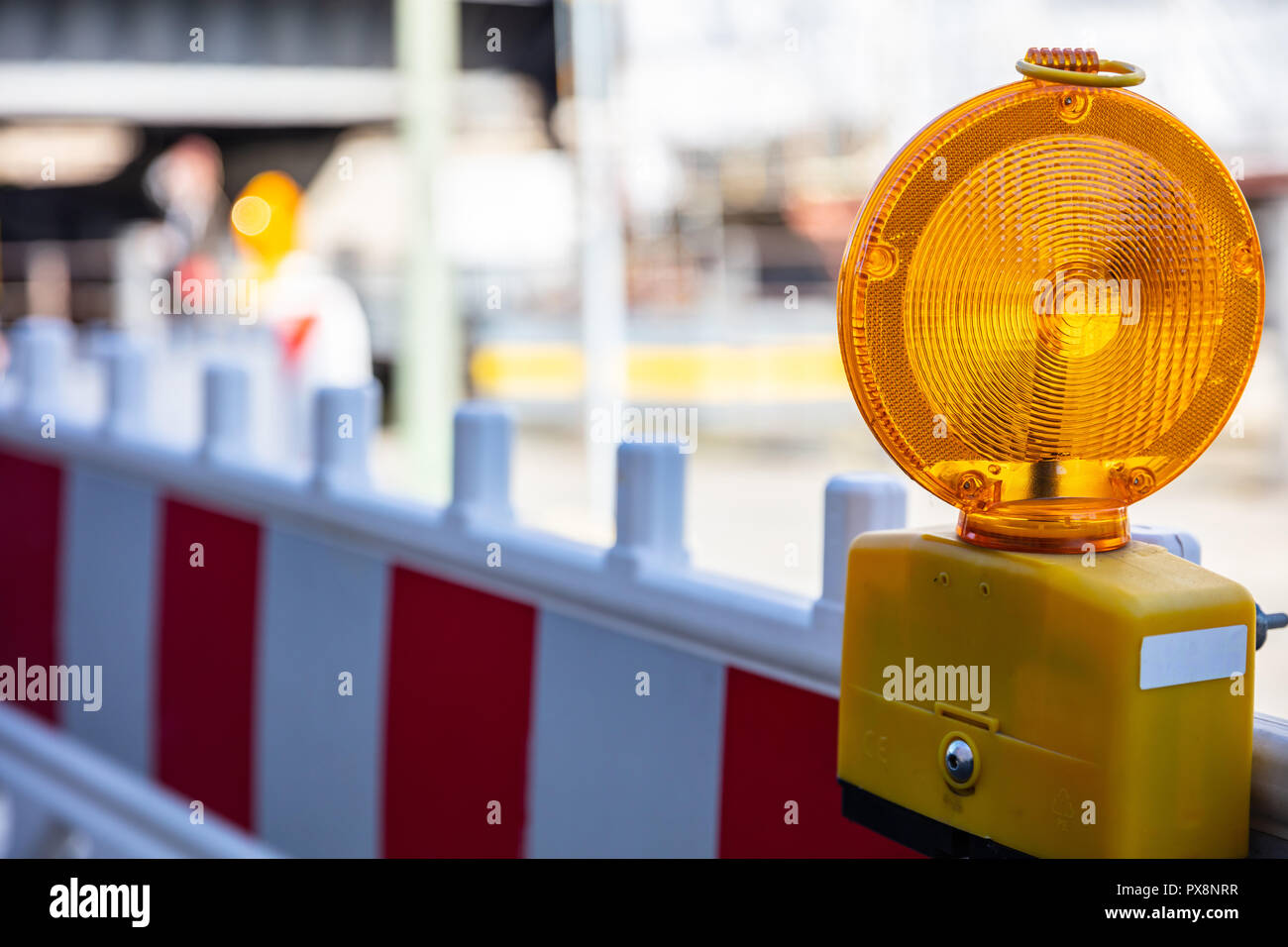 Sito in costruzione e la sicurezza. Street barricade con spia di avvertenza su una strada, sfocatura dello sfondo del sito Foto Stock