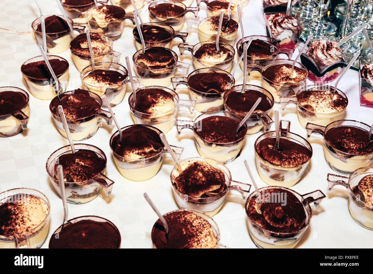 Molte tazze di panna cotta spolverato di cioccolato in polvere Foto Stock