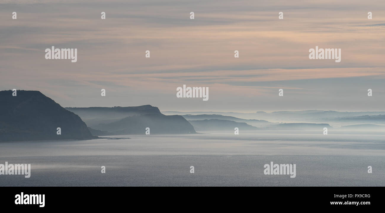 Charmouth, Dorset, Regno Unito. Xx Ottobre 2018. Meteo REGNO UNITO: Early Morning mist sorge oltre il Golden Cap e le scogliere lungo la Jurassic Coast vicino a Charmouth. Credito: Celia McMahon/Alamy Live News Foto Stock