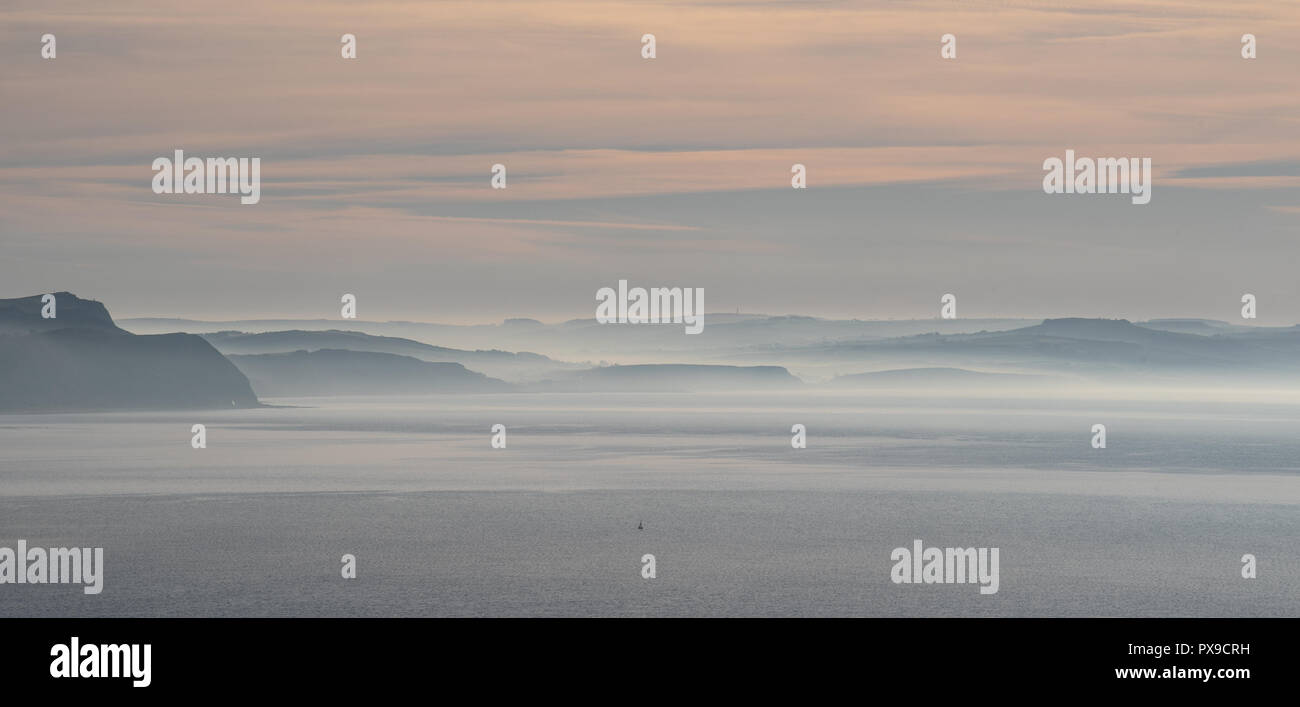 Charmouth, Dorset, Regno Unito. Xx Ottobre 2018. Meteo REGNO UNITO: Early Morning mist sorge oltre il Golden Cap e le scogliere lungo la Jurassic Coast vicino a Charmouth. Credito: Celia McMahon/Alamy Live News Foto Stock