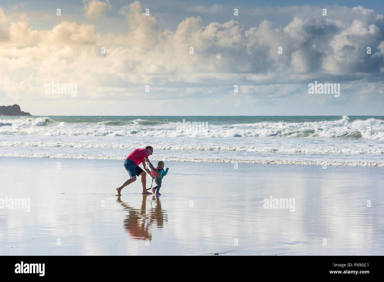 Un nonno divertendosi con la sua nipote su Fistral Beach in Newquay in Cornovaglia. Foto Stock