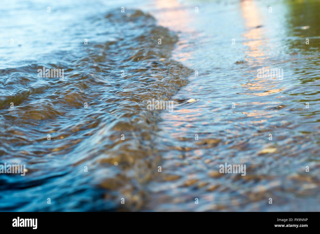 Fiume Volga. Estate, giornata di sole. L'onda precipita verso la spiaggia sabbiosa. Schiuma e bolle. Close-up. La Russia. Foto Stock