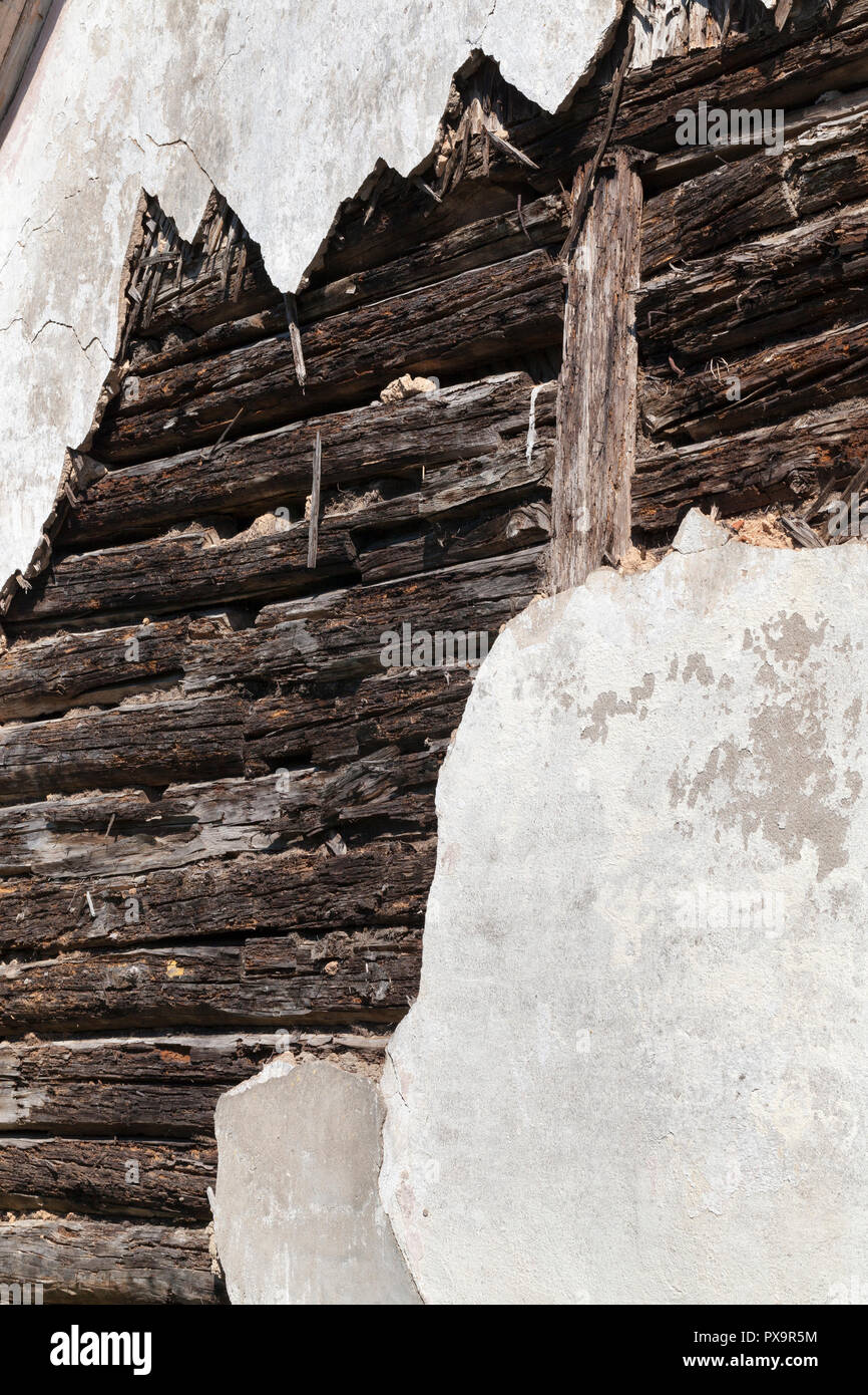 Intonaco rotto su un vecchio edificio di tronchi di legno, che ha cominciato a rot e rompere, primo piano Foto Stock
