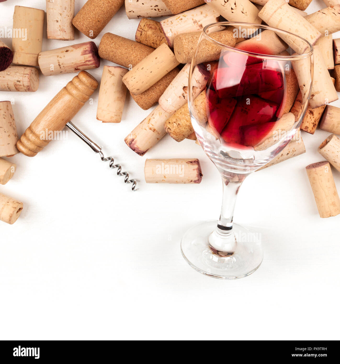 Bicchiere di vino rosso con tappi e cavatappi su uno sfondo bianco con  copia spazio, top shot Foto stock - Alamy
