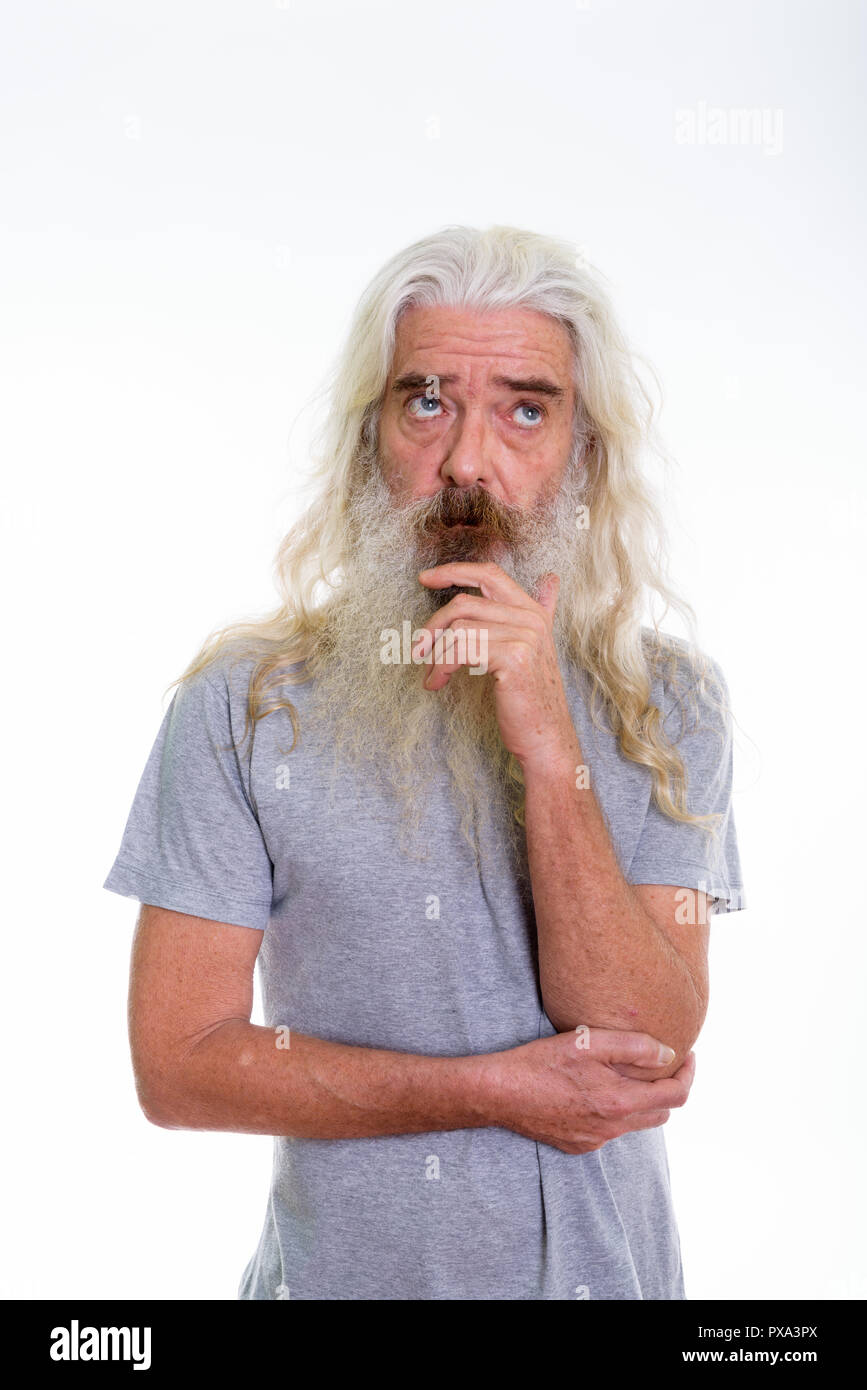 Studio shot di senior uomo barbuto pensare guardando in alto Foto Stock