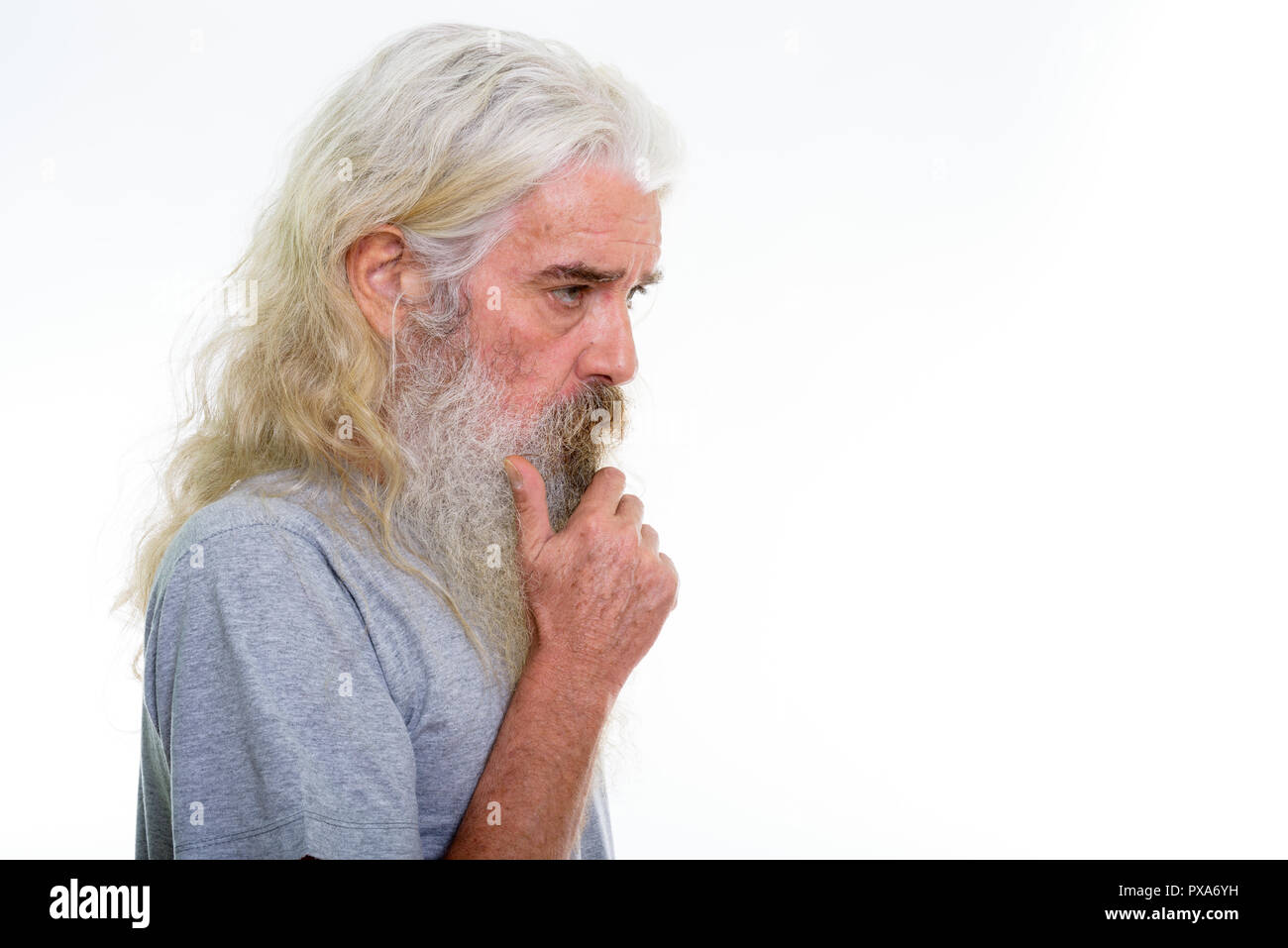 Vista di profilo di senior uomo barbuto pensando con mano sul mento Foto Stock