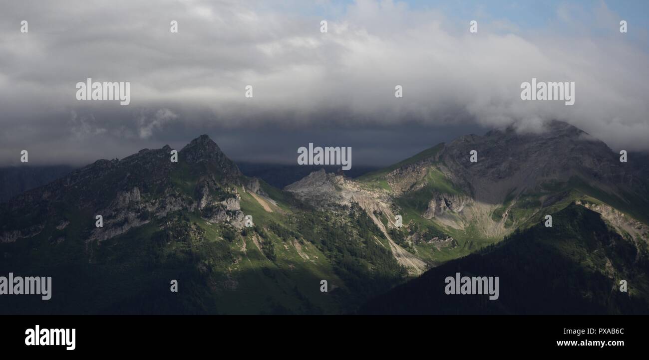 Picchi di montagna oscurata da nuvole Foto Stock