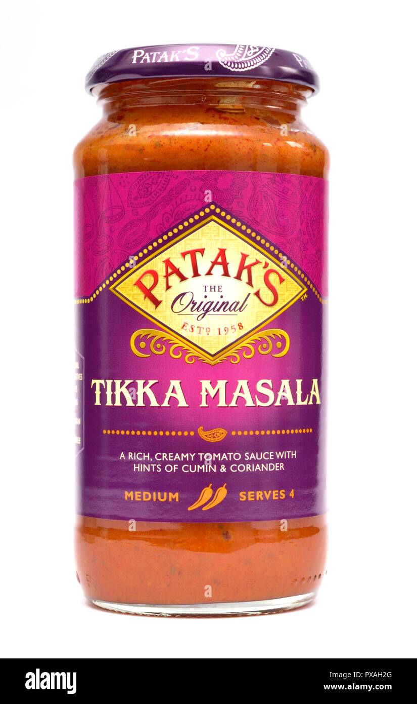 Un vaso di vetro di Pataks Tikka Masala,ricca cremosa salsa di pomodoro con un accenno di cumino e coriandolo su un bianco di sfondo per studio Foto Stock