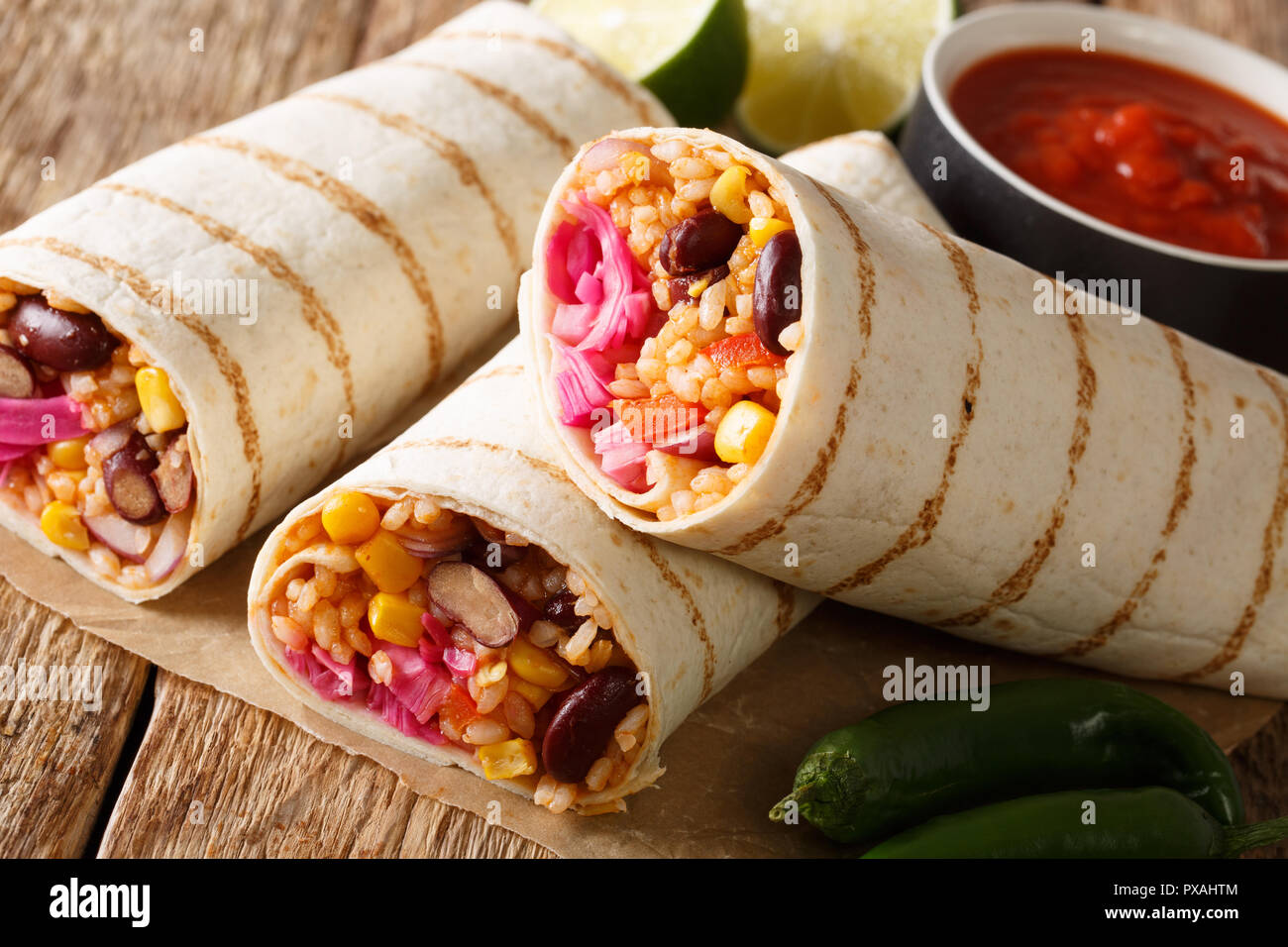 Il fast food grigliate di veggie burrito con riso e verdure vicino sul tavolo. orizzontale, stile rustico Foto Stock