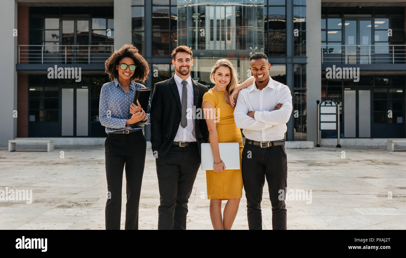 Diversi gruppi di persone di affari in piedi insieme all'esterno. Uomini e donne guardando la fotocamera e sorridente. Foto Stock