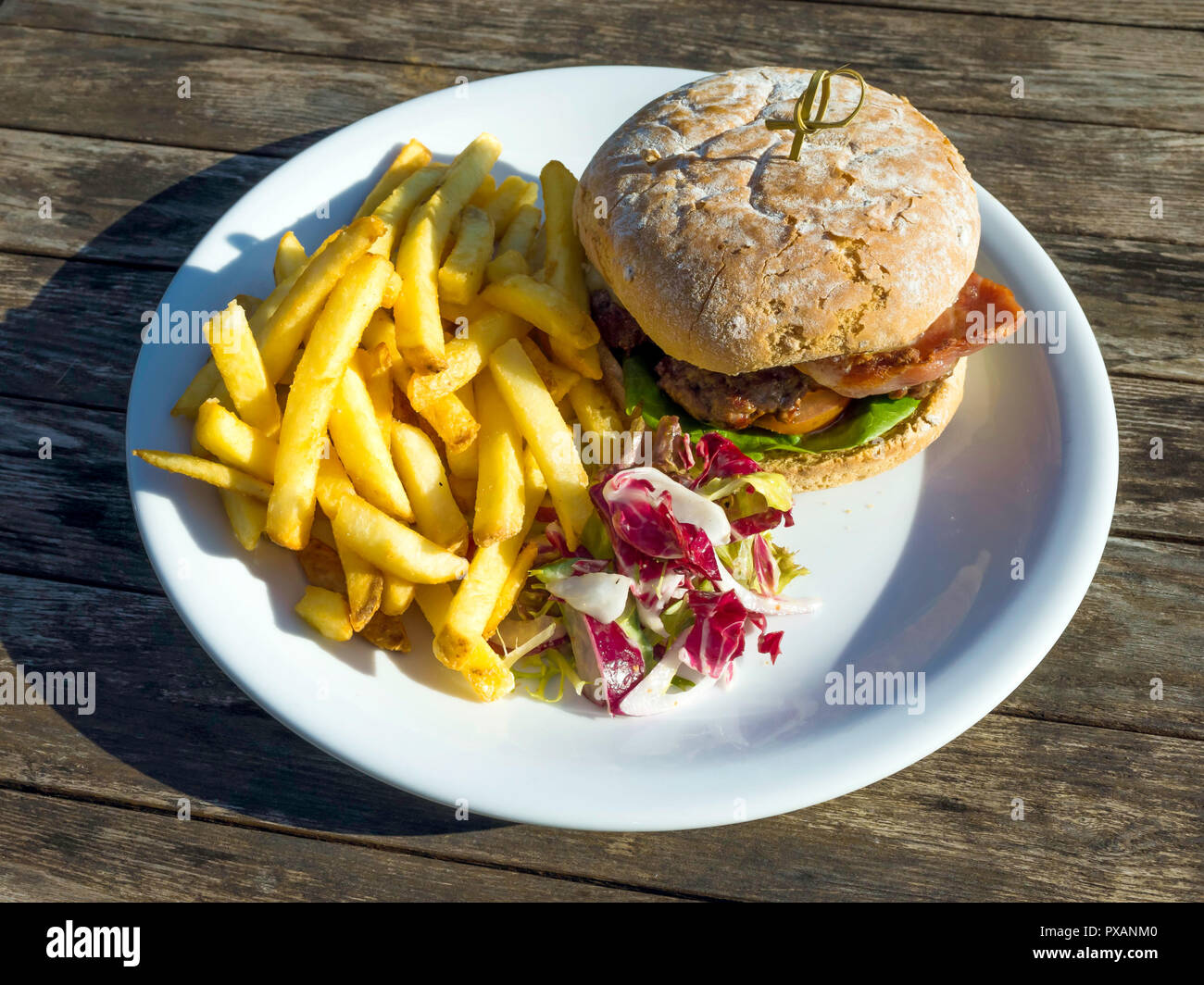 Cafe pranzo un primo hamburger di manzo con formaggio pancetta patate fritte e insalata mista Foto Stock
