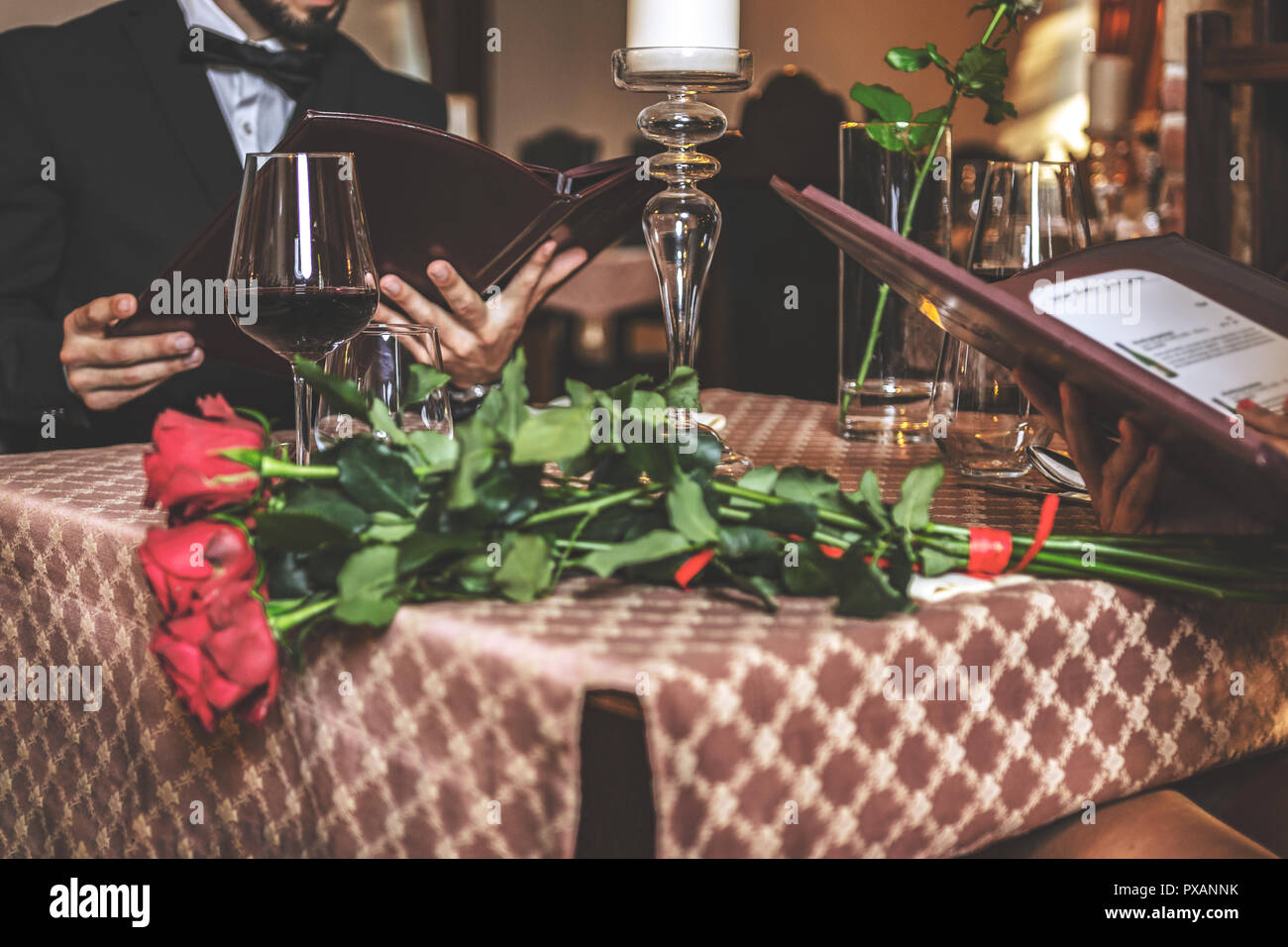 Elegante giovane in amore la lettura di un menu durante una romantica cena in un ristorante di close-up (messa a fuoco selettiva) Foto Stock