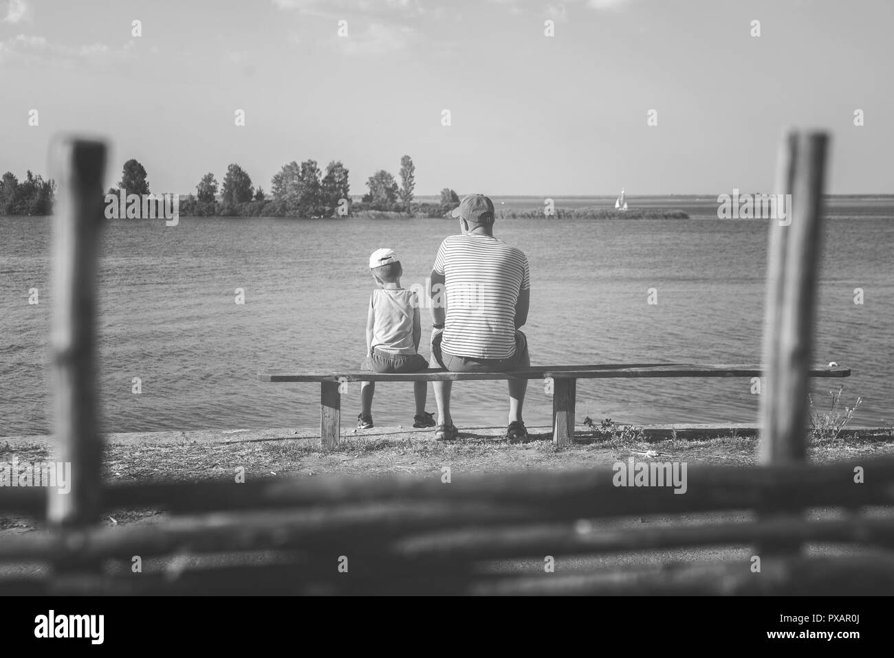 Padre e figlio seduti su un banco di lavoro Foto Stock