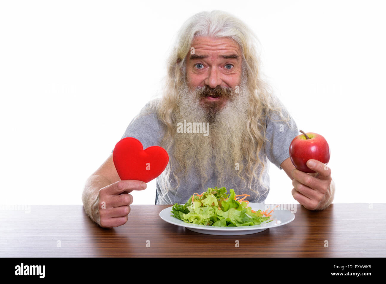 Studio shot di felice senior barbuto uomo sorridente tenendo ri Foto Stock