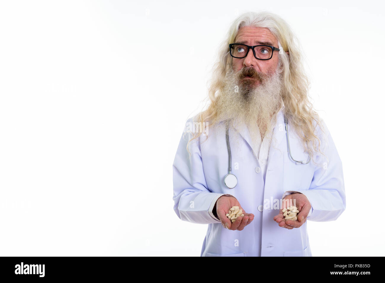 Studio shot di senior uomo barbuto medico indossando occhiali whil Foto Stock