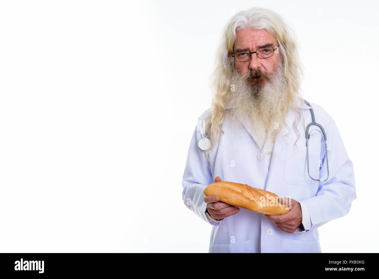 Studio shot di senior uomo barbuto medico indossando occhiali whil Foto Stock