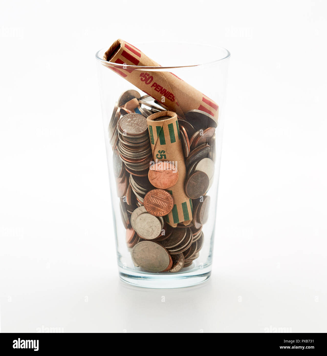 Il vasetto di vetro di monete in tazza sulla scrivania il risparmio di denaro debito ricca banca poveri dollar finanziare la ricchezza cambia mercato cash Foto Stock