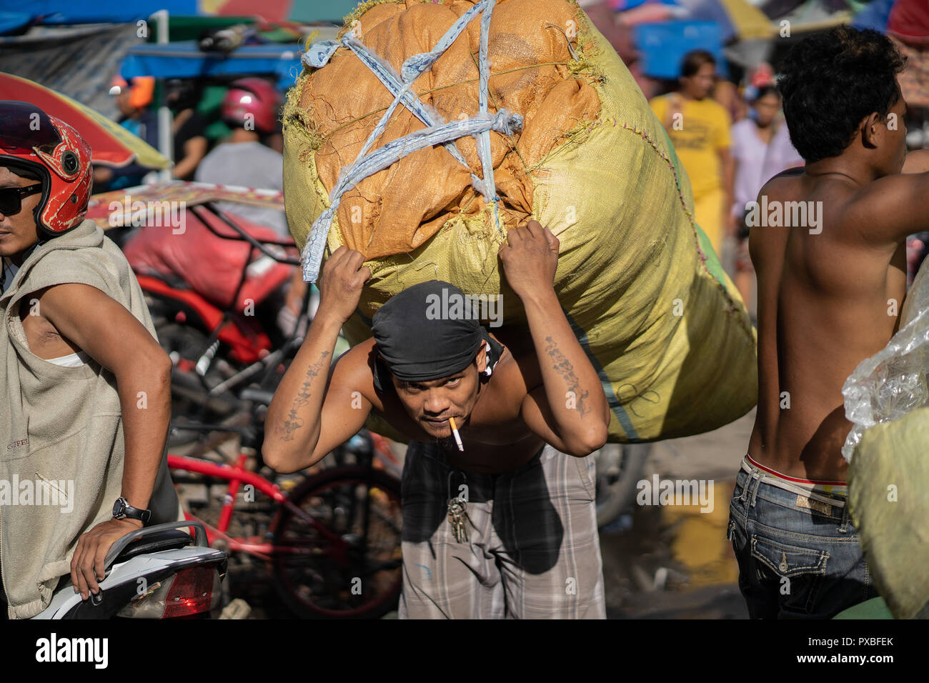 Un filippino uomo porta un sacco di grandi carichi di merci,Cebu City,Phiulippines Foto Stock