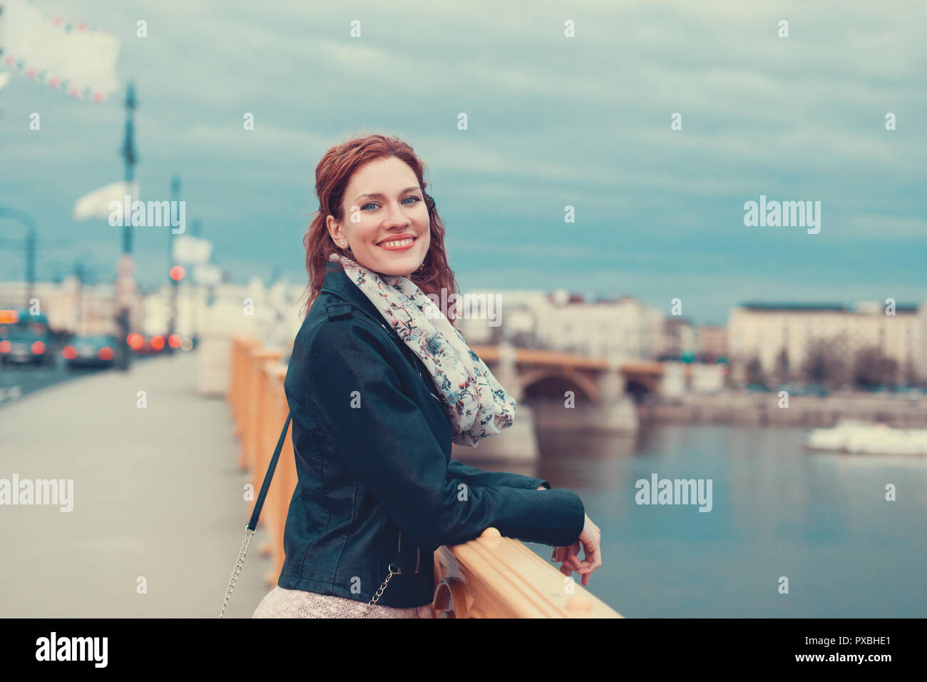 Felice giovani 20s redhead urban donna sorriso sul ponte Margherita, Budapest, Ungheria Foto Stock