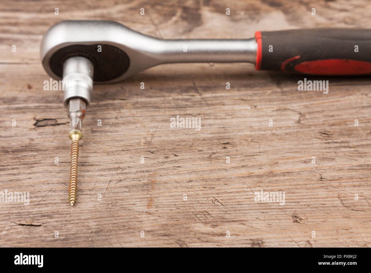 Chiave con testa di avvitamento giace contro il background di legno. Close-up Foto Stock