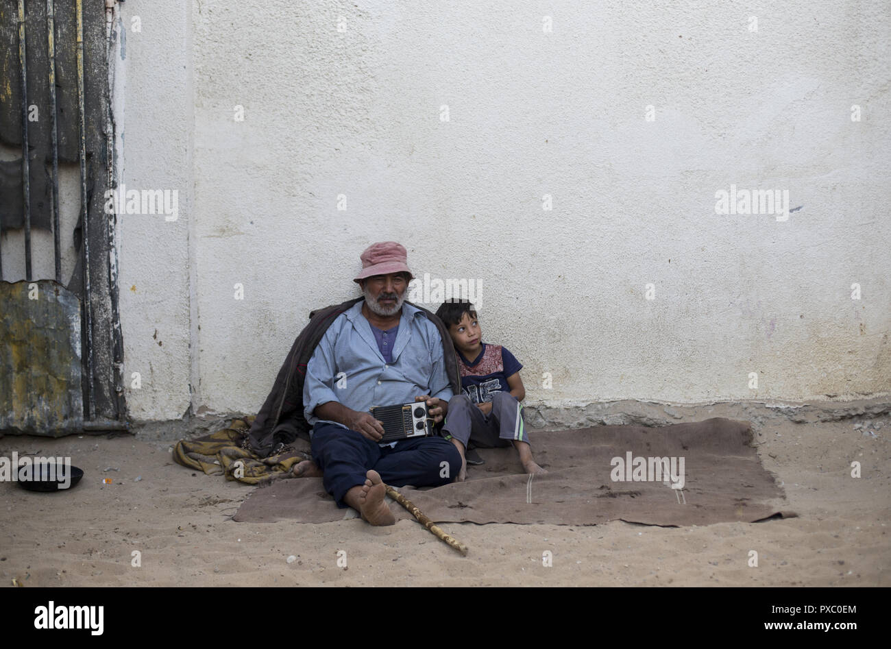 La città di Gaza, la striscia di Gaza, la Palestina. Xx oct, 2018. I rifugiati palestinesi sedersi al di fuori della loro casa temporanea nella città di Beit Lahiya nel nord della Striscia di Gaza. Palestinesi soffrono di un elevato tasso di disoccupazione e la carenza di lavoro nella Striscia di Gaza. Un numero crescente di famiglie si trovano ad affrontare la povertà dopo la perdita del lavoro durante gli ultimi dieci anni di embargo di Gaza e tre guerre israeliana nella Striscia di Gaza. Credito: Mahmoud Issa/Quds Net News/ZUMA filo/Alamy Live News Foto Stock