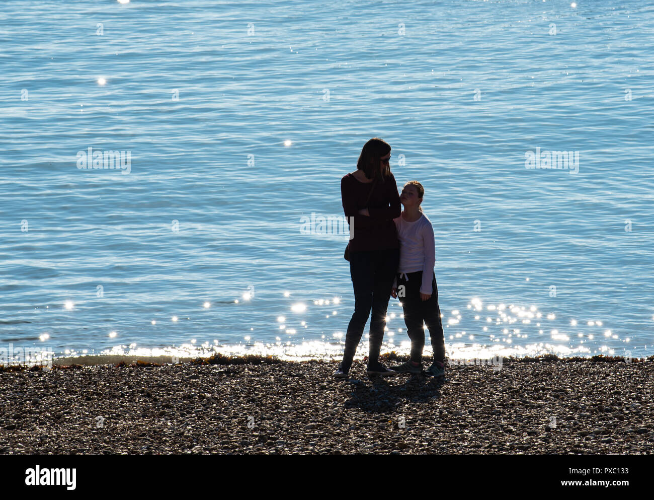 Lyme Regis, Dorset, Regno Unito. Il 21 ottobre 2018. Regno Unito: Meteo persone pagaia in mare scintillanti unseasonably in climi caldi come il resort costiero di Lyme Regis si crogiola nel caldo sole del fine settimana. Credito: Celia McMahon/Alamy Live News Foto Stock