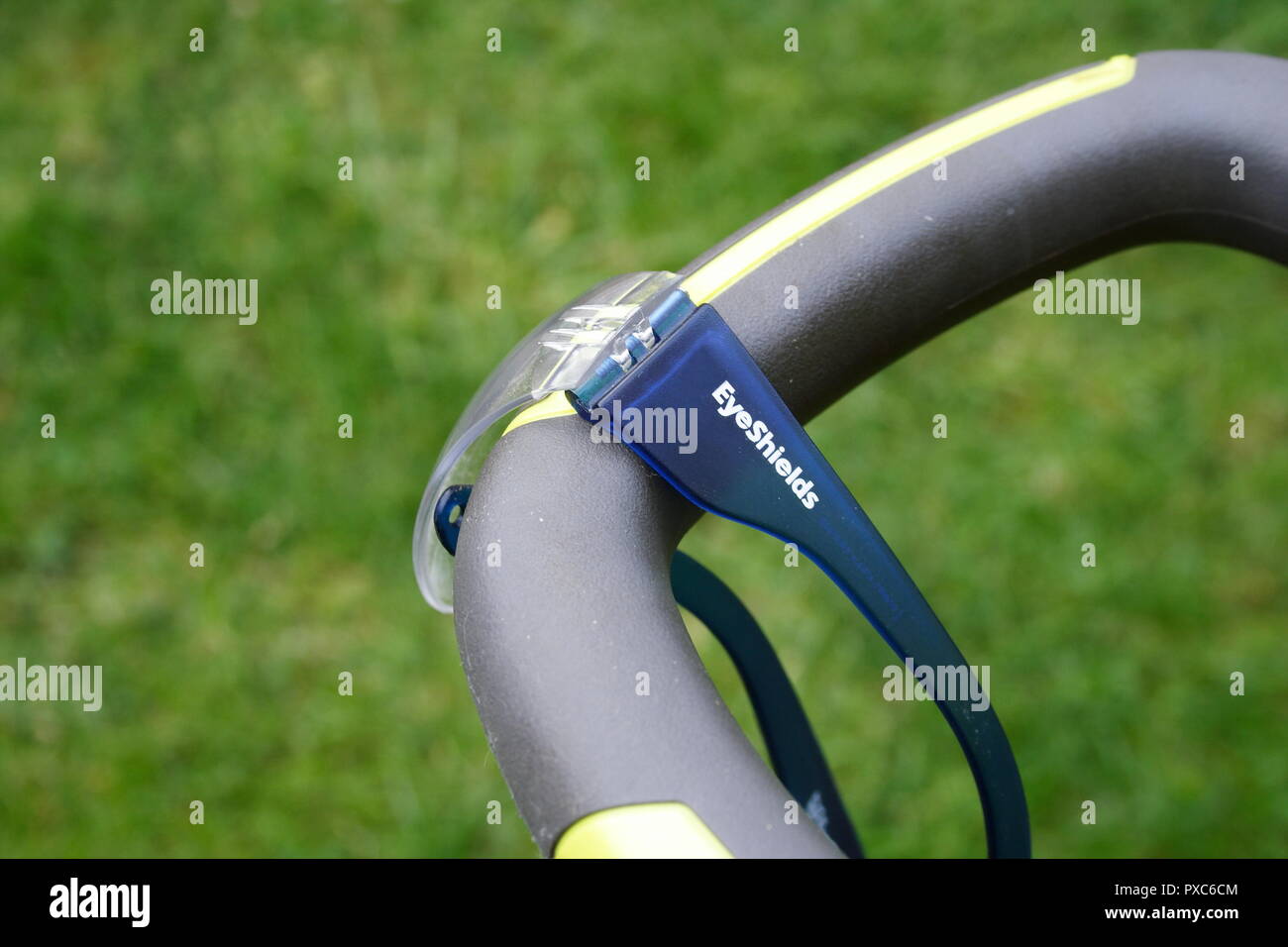 Protezione degli occhi occhiali appesi al manubrio di un elettrico rasaerba Foto Stock