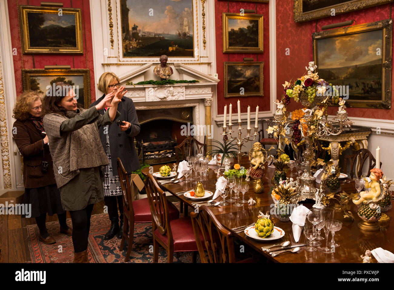 Regno Unito, Inghilterra, Yorkshire, Castle Howard a Natale, Crimson Sala Da Pranzo, Charlotte Lloyd-Webber parlando di tabella e le decorazioni della stanza. Foto Stock