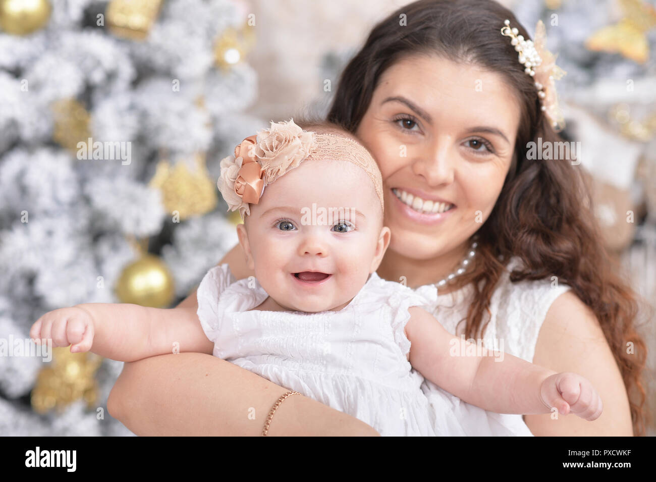 Madre con graziosi figlia in posa in camera Foto Stock