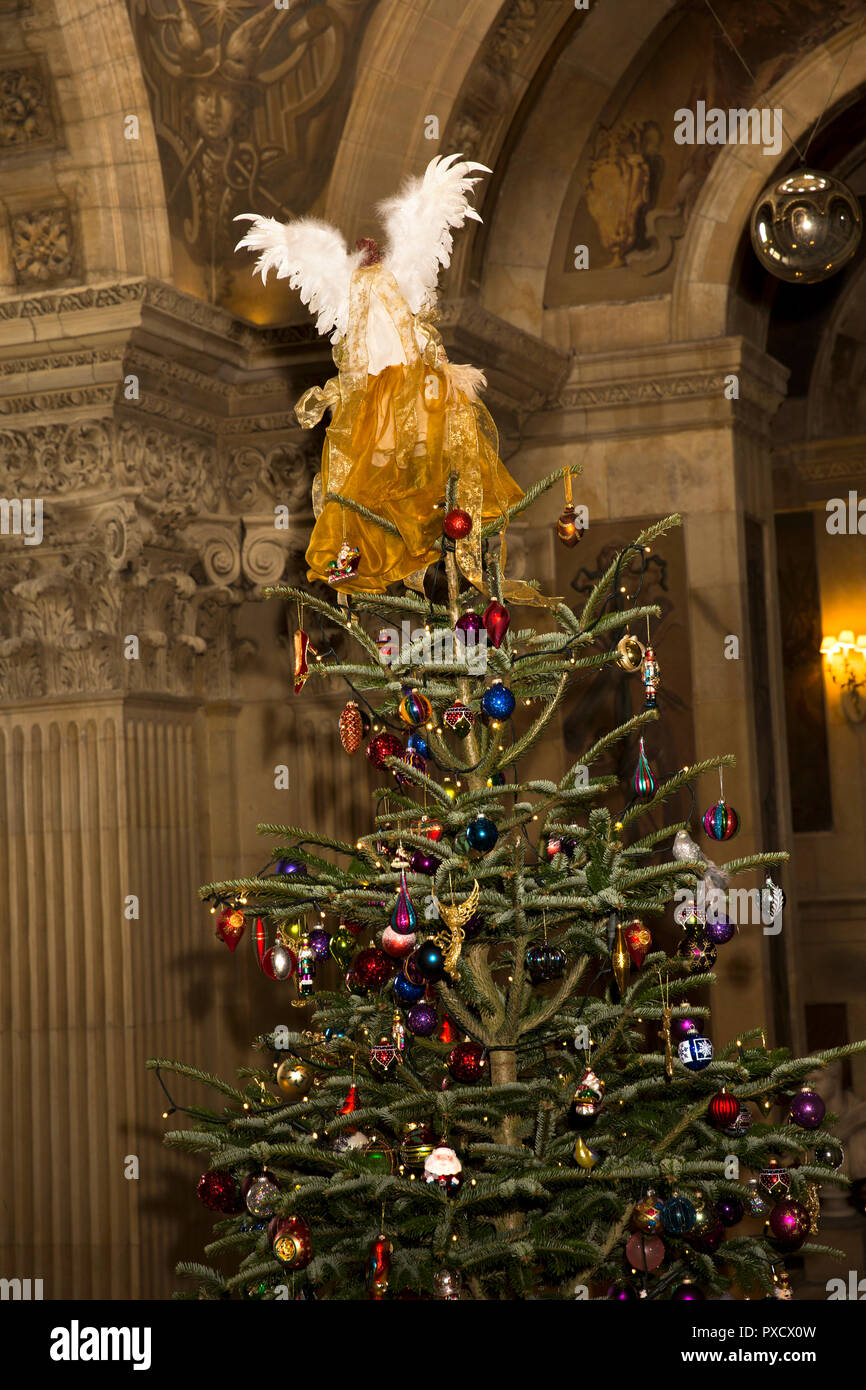 Regno Unito, Inghilterra, Yorkshire, Castle Howard a Natale, grande hall, angelo sulla sommità di un enorme albero di Natale decorato Foto Stock