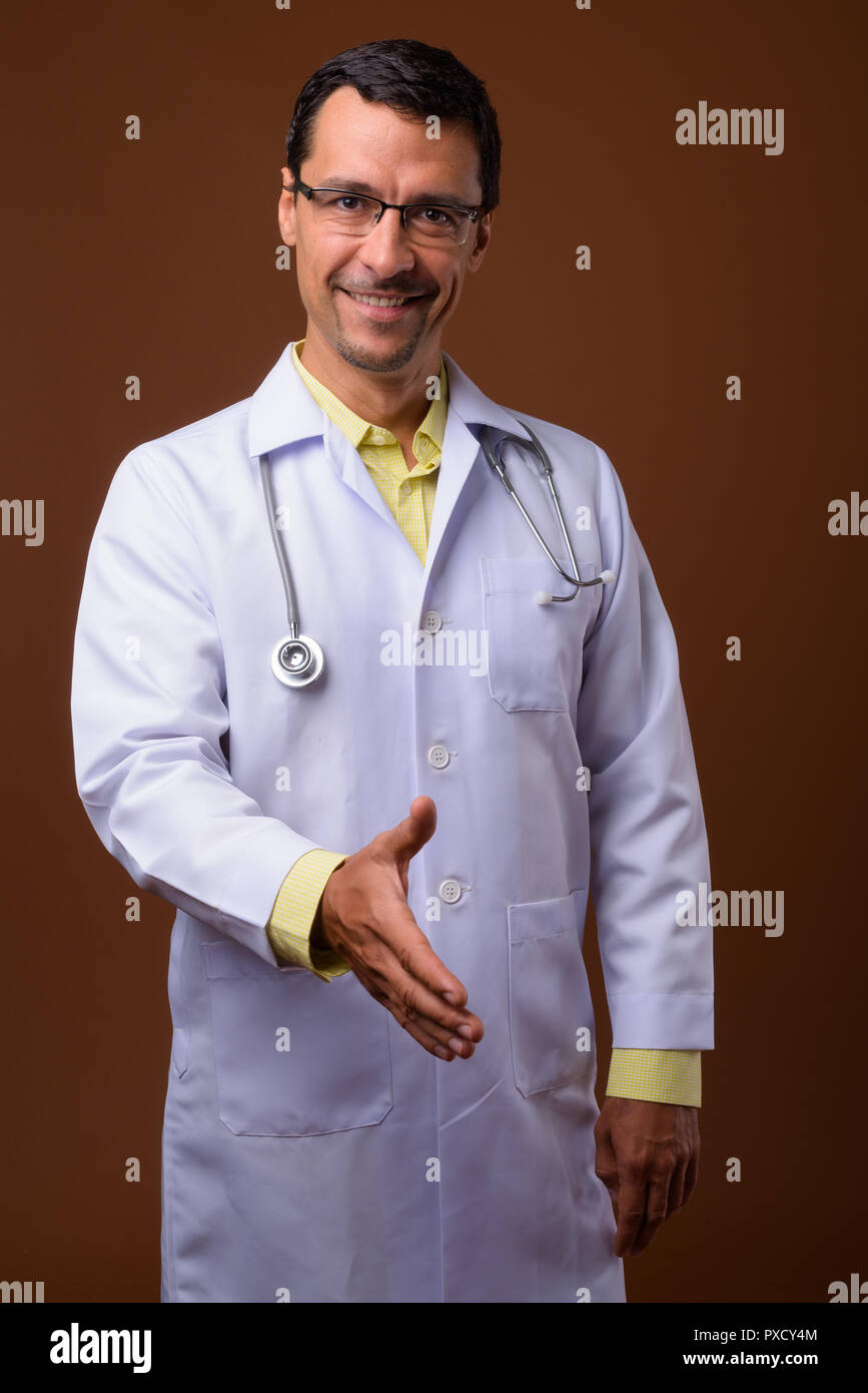 Ritratto di uomo bello medico offrendo stretta di mano e sorriso Foto Stock