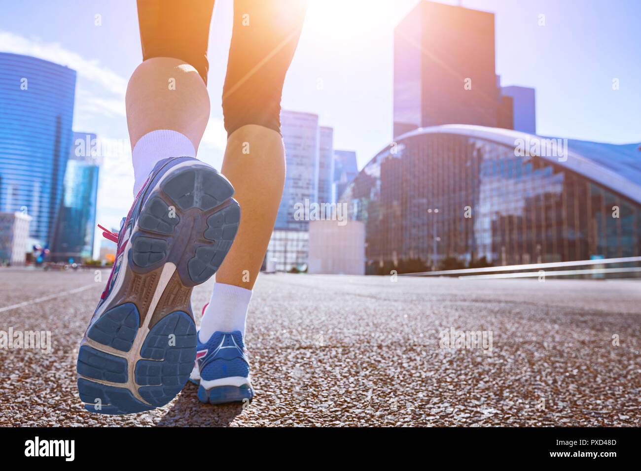 Jogging in città, primo piano delle scarpe da running, donna attivo facendo mattina allenamento fitness nel paesaggio urbano, gambe del pareggiatore, uno stile di vita sano Foto Stock