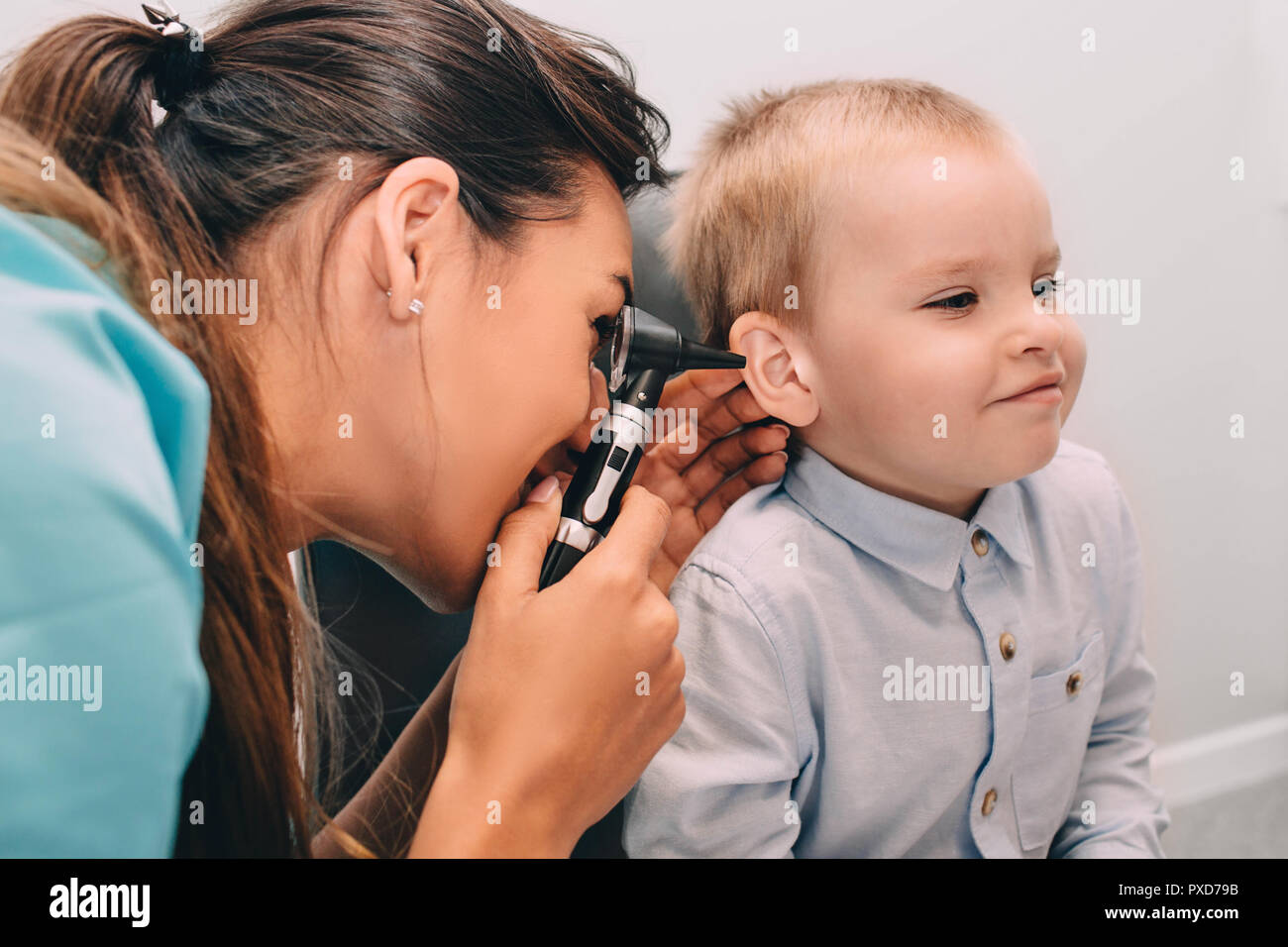 Sorridente ragazzino avente orecchio esame con otoscopio Foto Stock