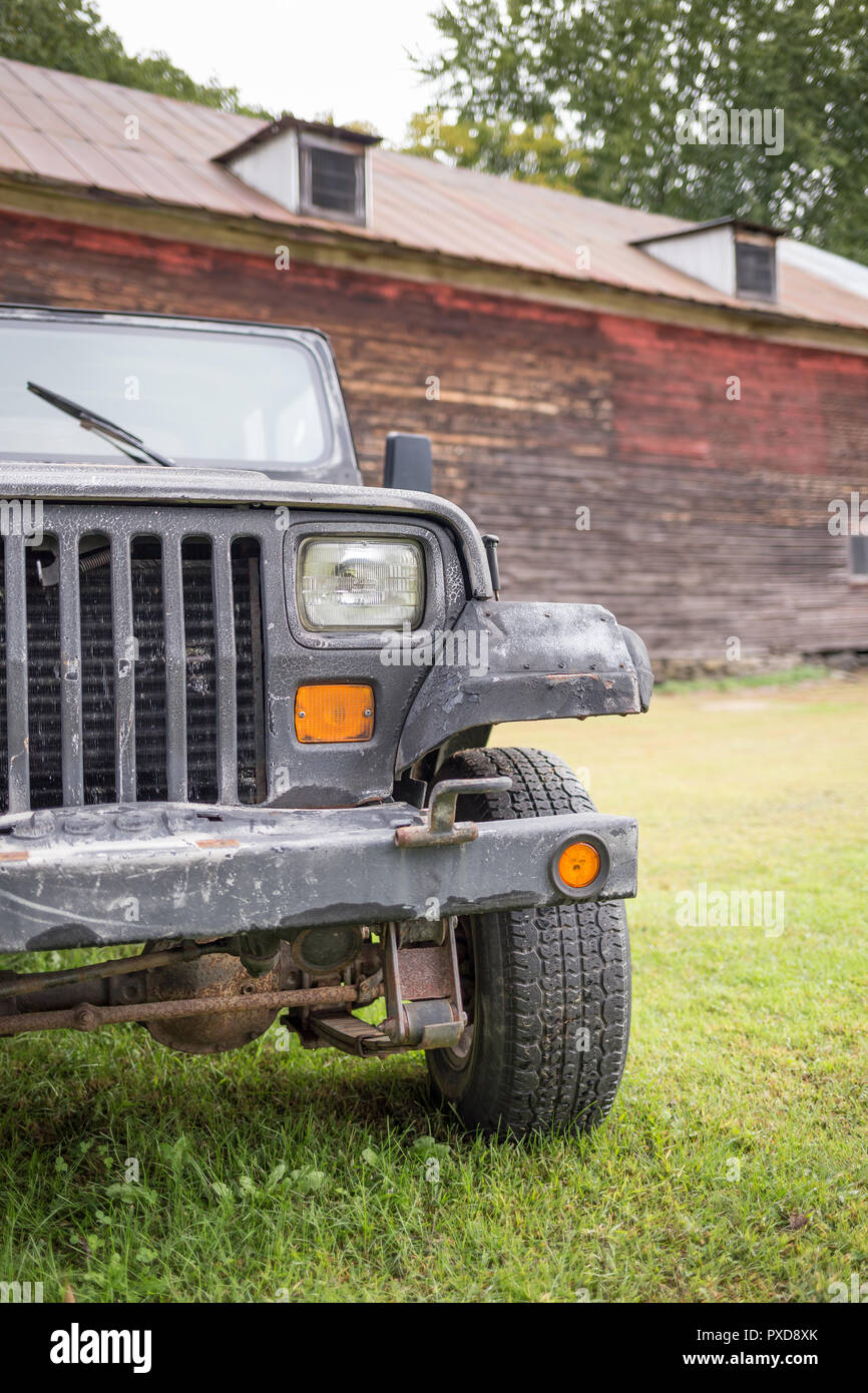 Un battito di vecchie Jeep 4x4 di fronte a un vecchio fienile. Foto Stock