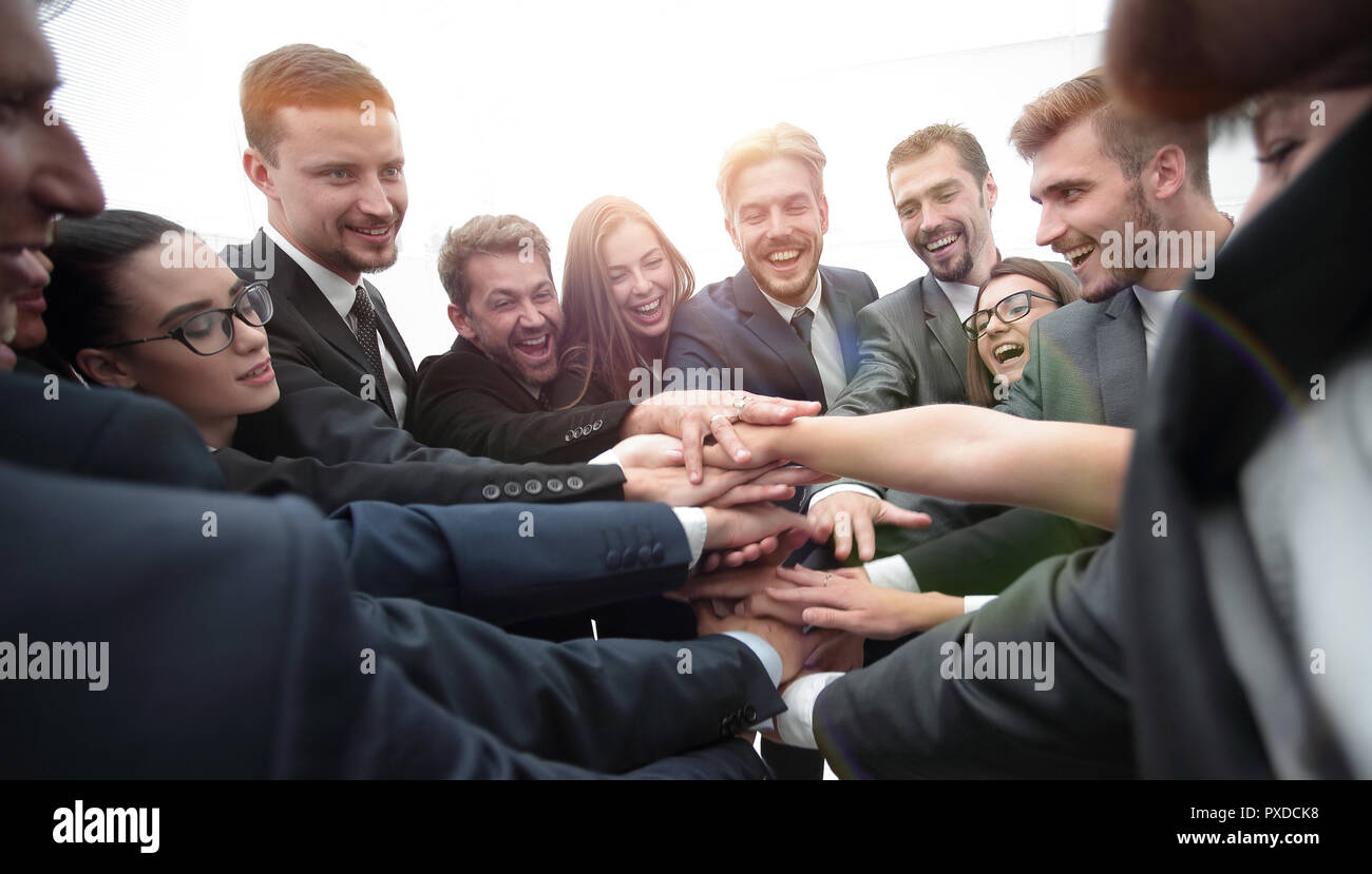 Un folto gruppo di persone di affari in piedi con le mani piegate insieme Foto Stock