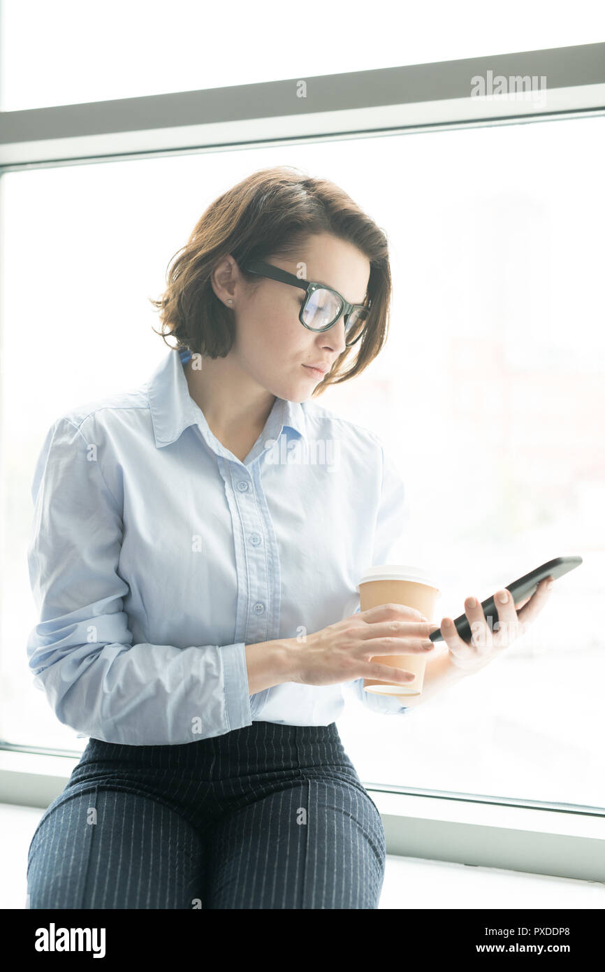 Gli affari seri lady controllo messaggio sul telefono Foto Stock