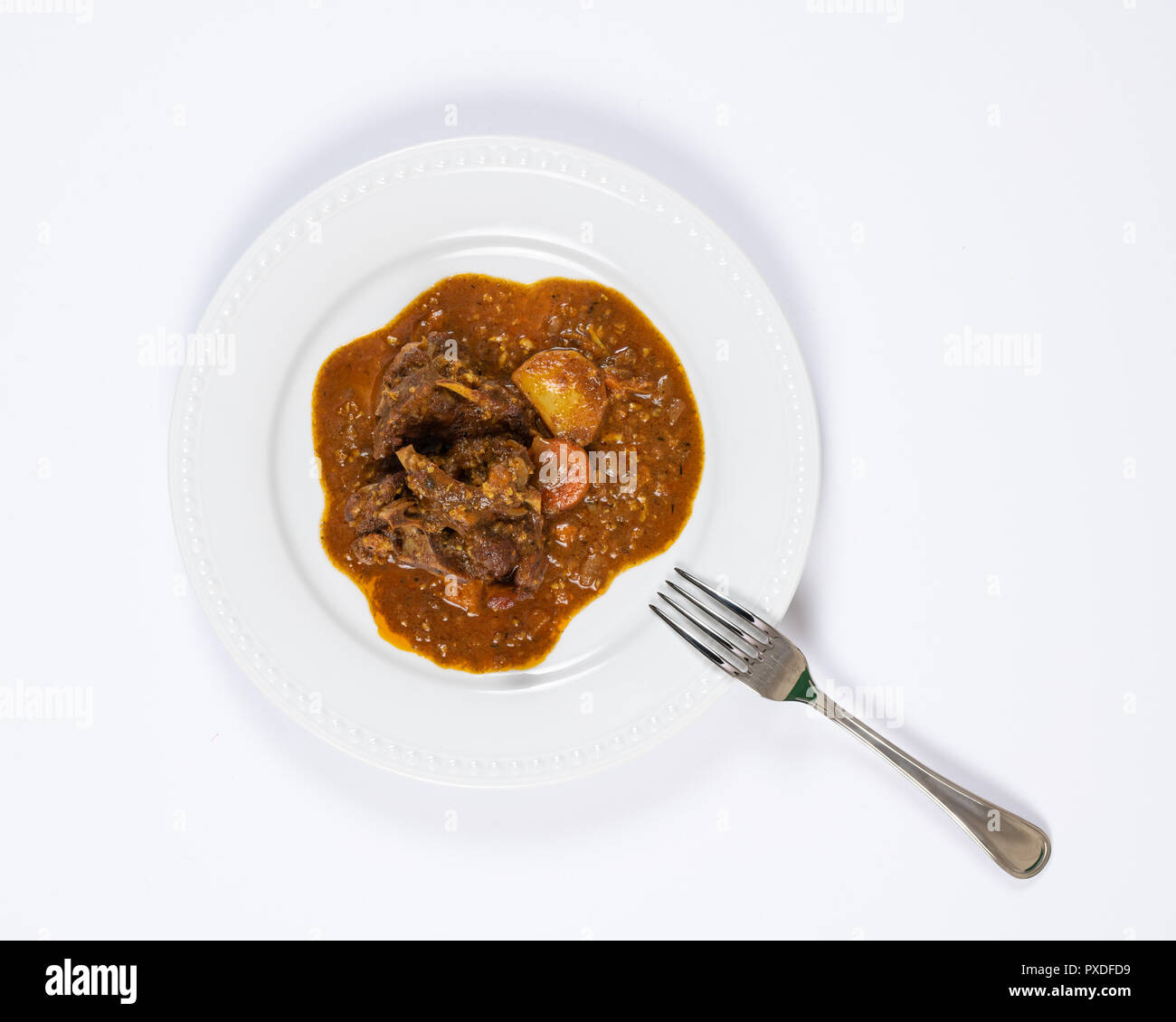 Close-up di piastra colorata stufato di capra con patate, carote, cipolle, la foglia di alloro e altre spezie. Foto Stock