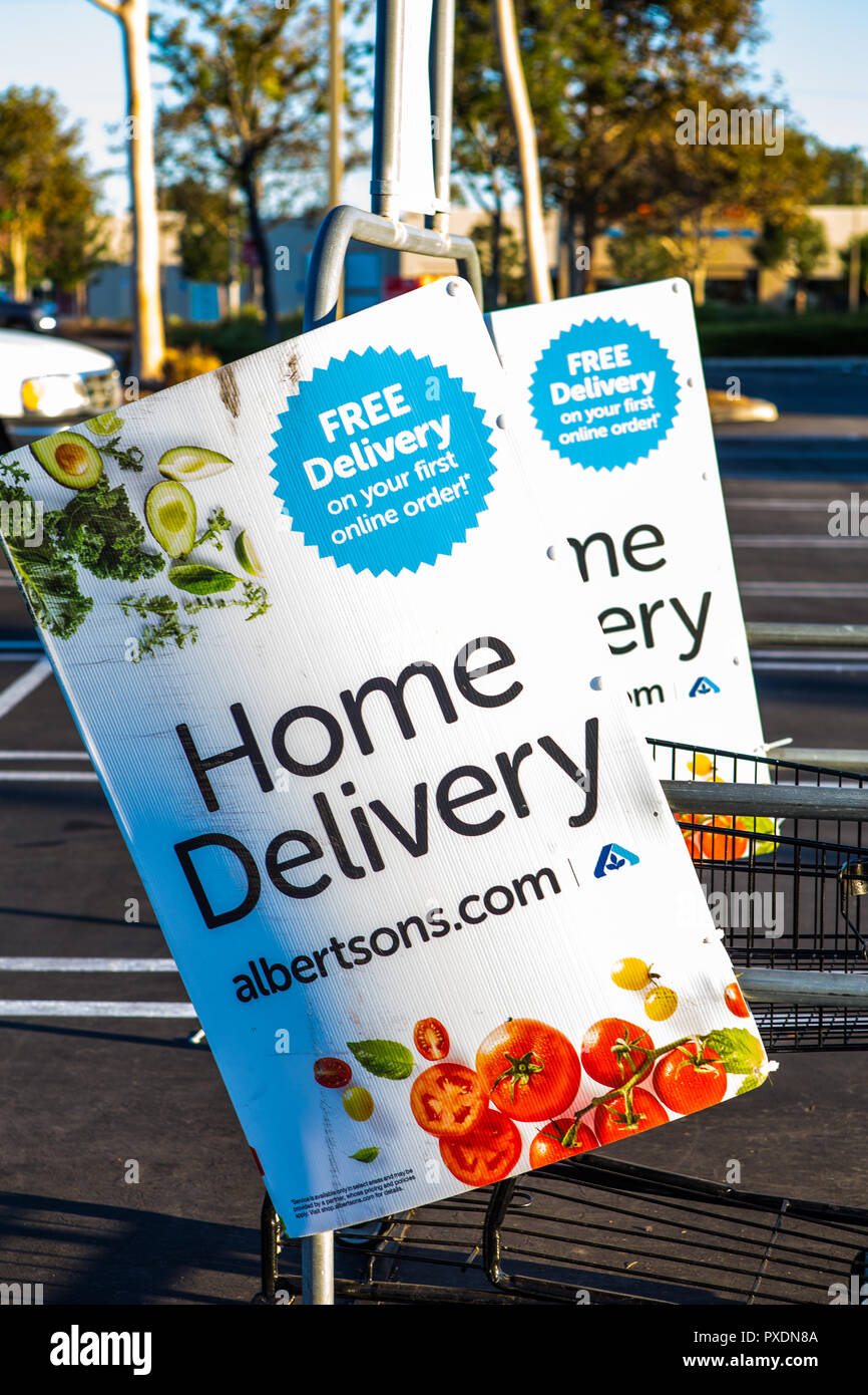 Americano società alimentari Albertsons pubblicità la loro consegna a domicilio Servizio di ordinazione online con segni nel loro parcheggio. Foto Stock