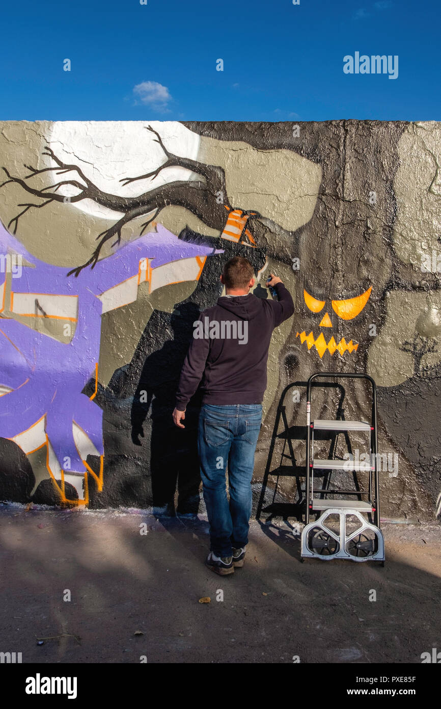 Berlino, Germania, Mauerpark 21 ottobre 2018. Artisti di strada redorate lo storico tracciato del Muro di Berlino. Pittori al Lavoro la creazione di un lungo artistico la pubblicità per la birra Sternburg. Foto Stock