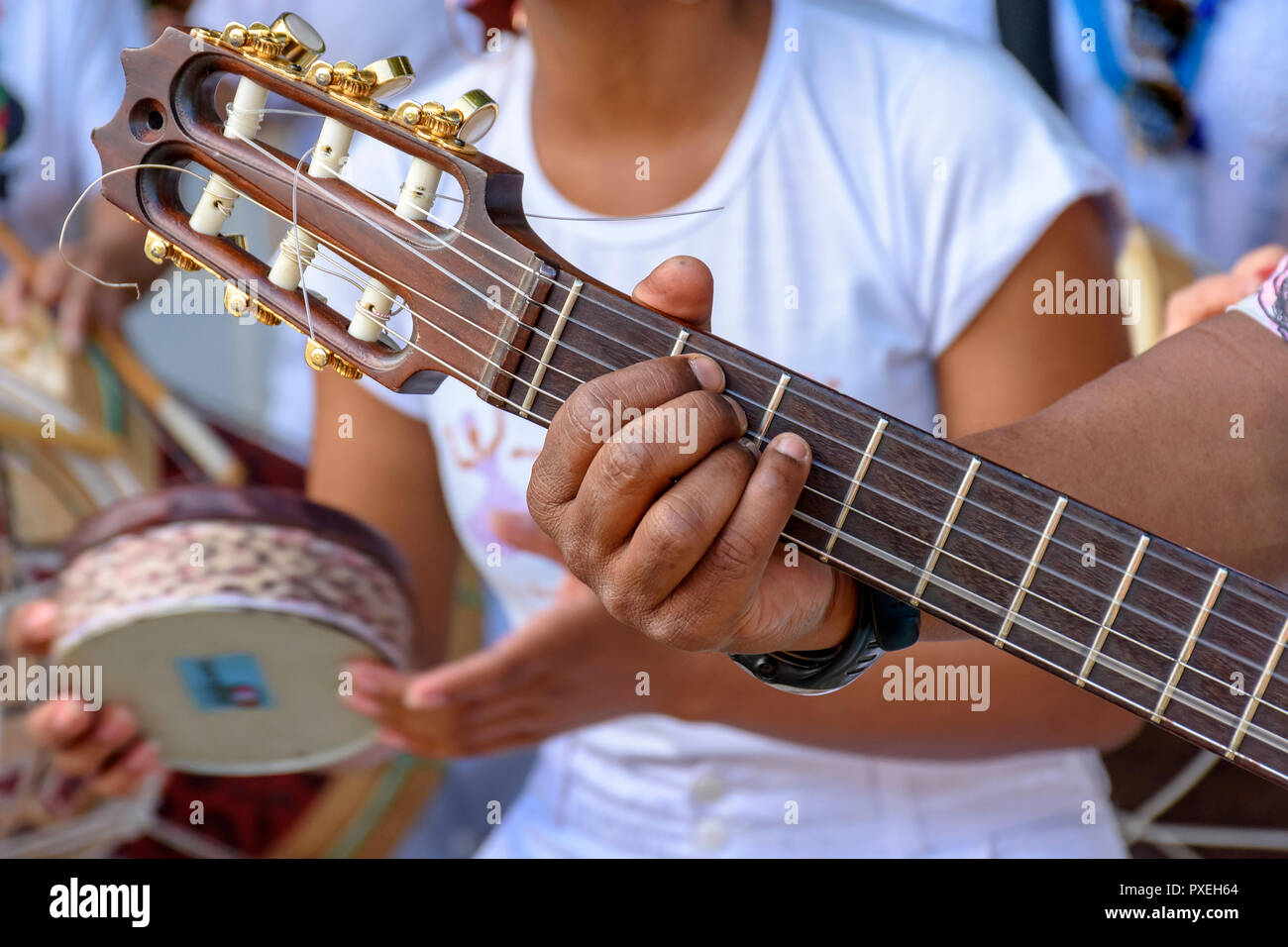 Dettaglio del chitarrista con le mani in mano e la sua chitarra acustica ad un outdoor presentazione samba Foto Stock